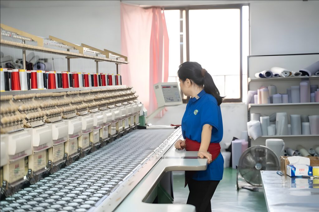 An operator watching a multi-head embroidery machine at work